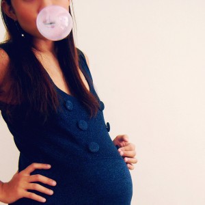 pregnant girl blowing a bubble with gum