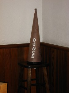 dunce cap on a stool in the corner of a classroom