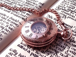 gold pocket watch on a calligraphied book